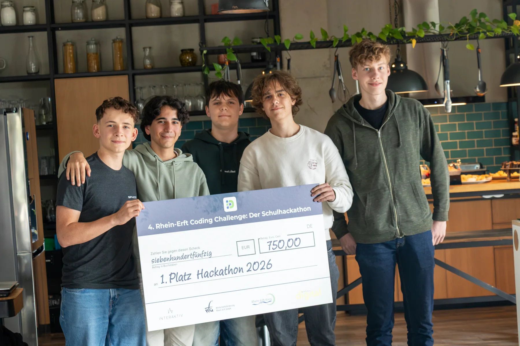 Das Gewinnerteam 2026 mit seinem Scheck
